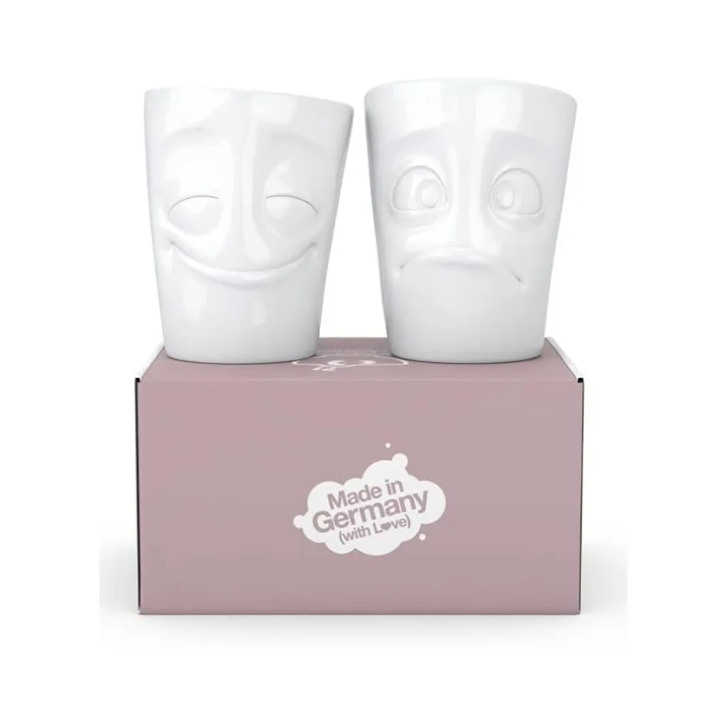 Set de deux mugs sans anse avec un visage joyeux et un autre suppliant, posés côte à côte.