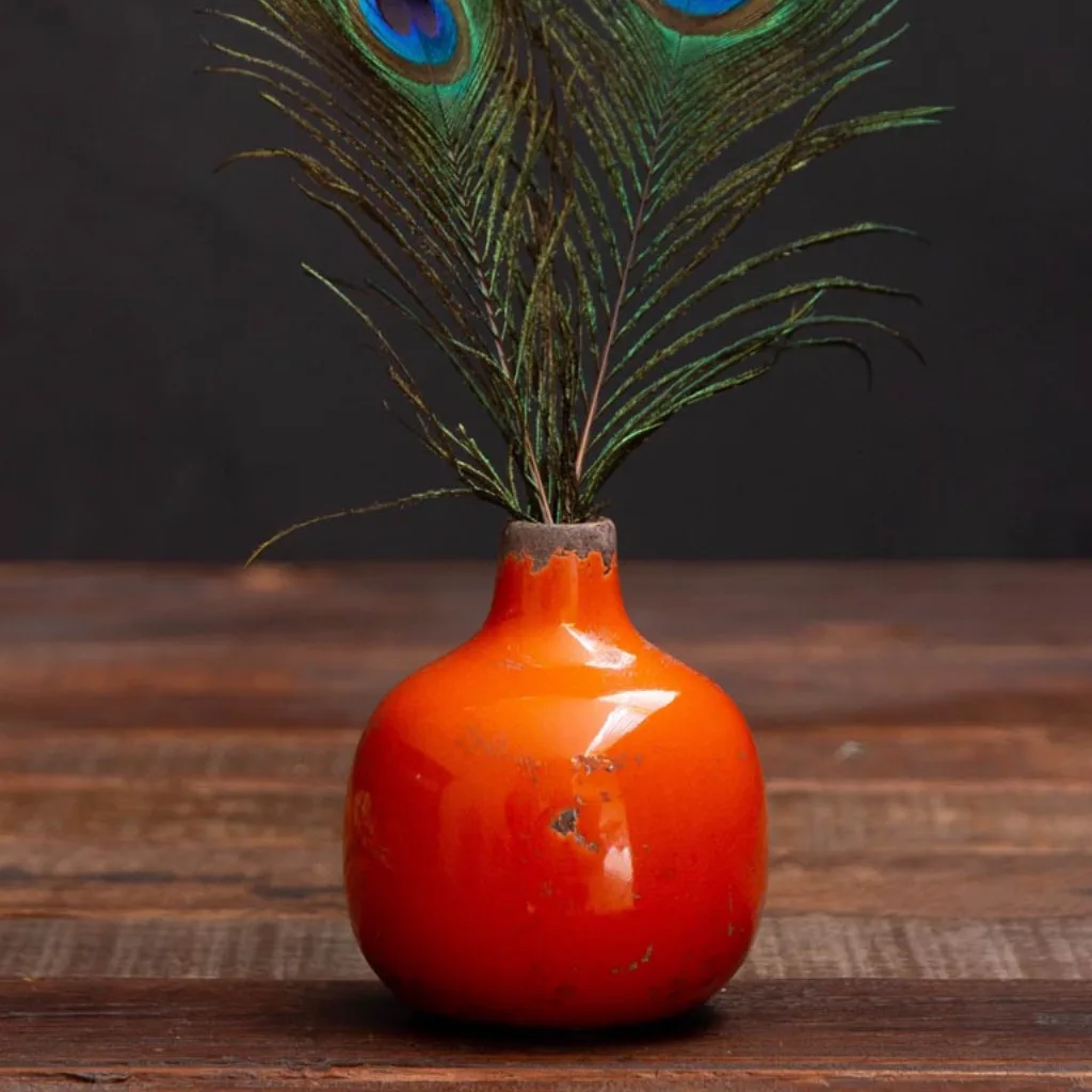 Gros plan sur la texture brute du vase orange en céramique