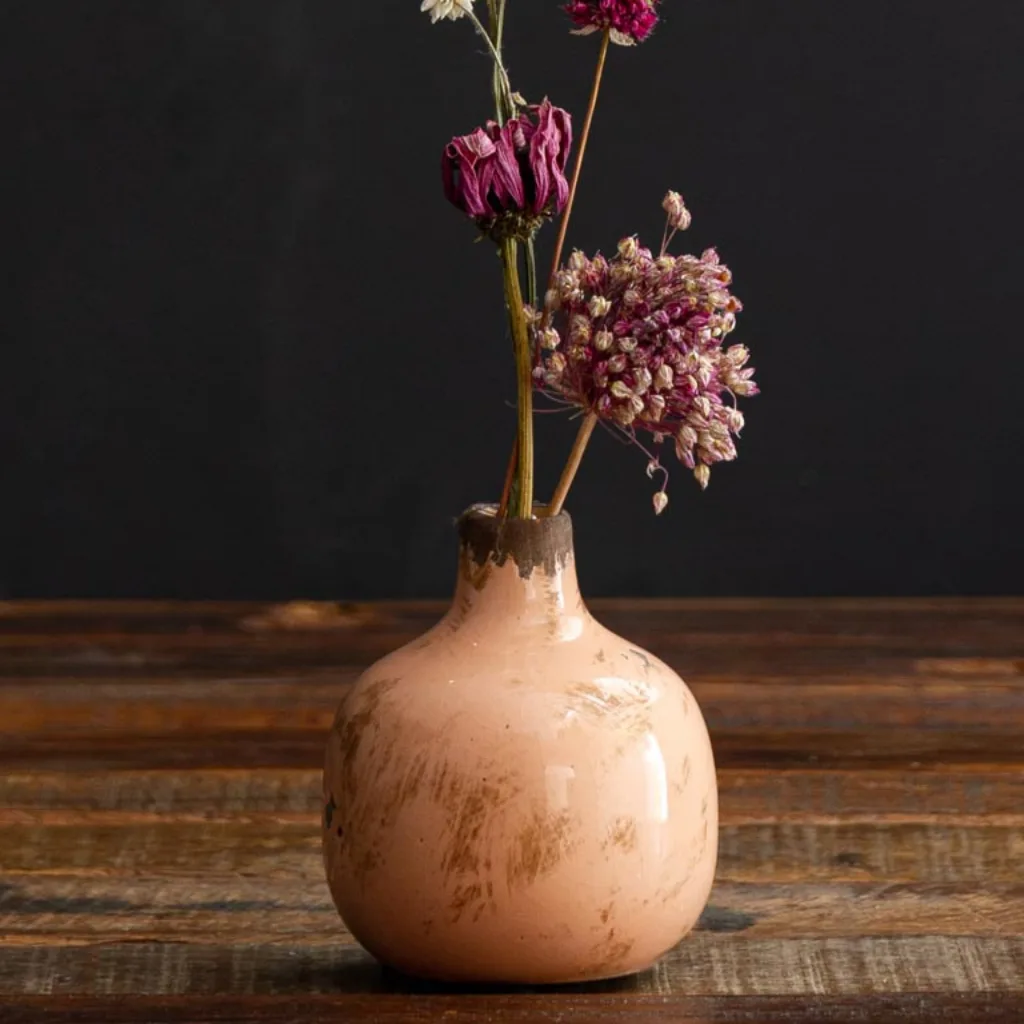 Gros plan sur les aspérités et la patine du vase céramique vieux rose
