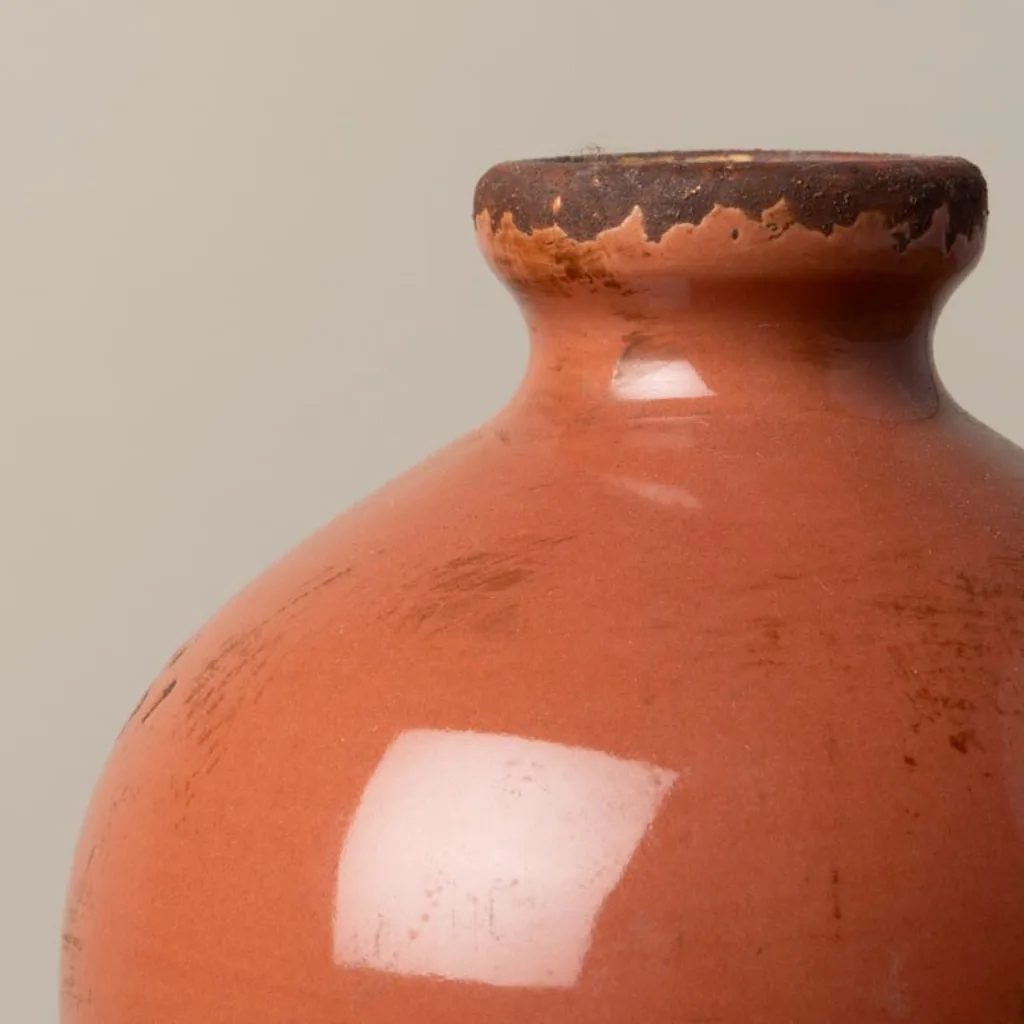 Gros plan sur la céramique du vase blush rouge, patine vieillie et détails artisanaux