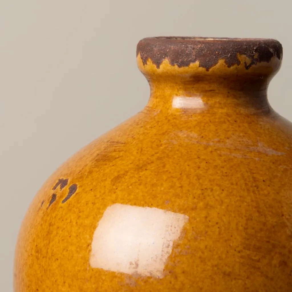 Gros plan sur les aspérités du vase marron glacé, finition céramique brute